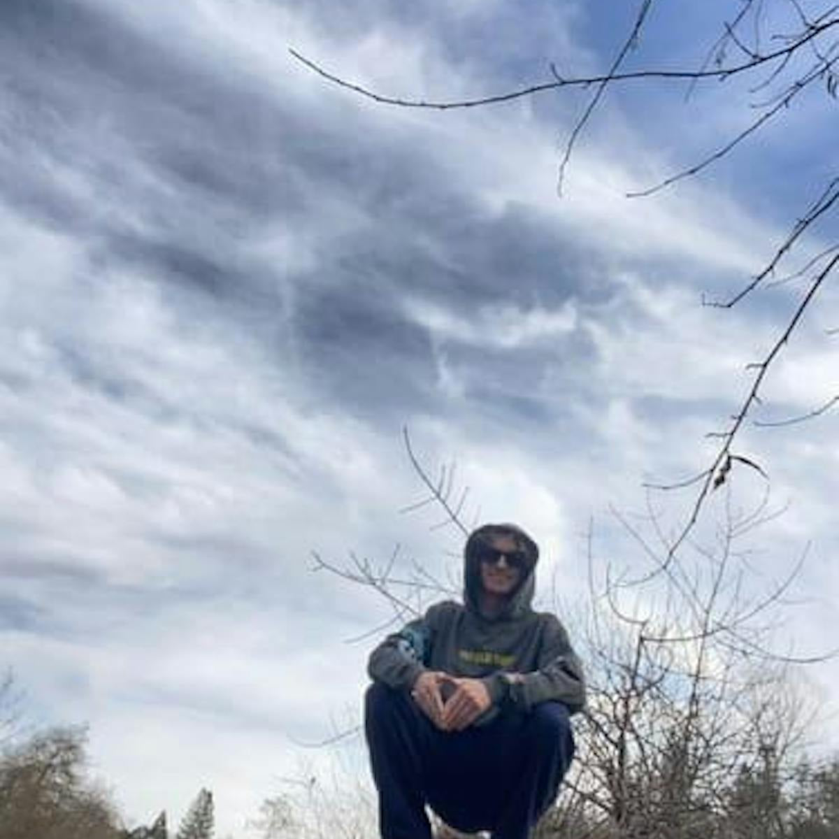Customer wearing Closing Chapter hoodie outdoors against a moody sky