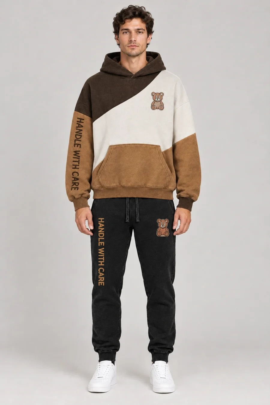 Model wearing the Handle With Care colorblock hoodie with matching black joggers, front